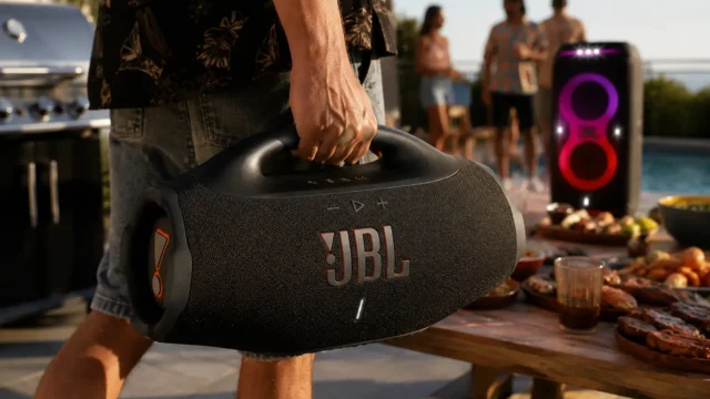 JBL Boombox 4 em área de churrasco com piscina ao fundo, destacando uso portátil em festa e resenha.